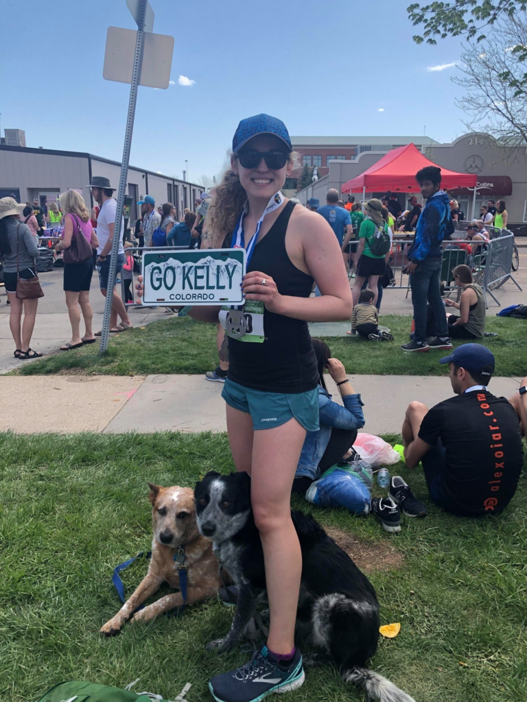 kelly at running race with her dogs holding sign says go kelly